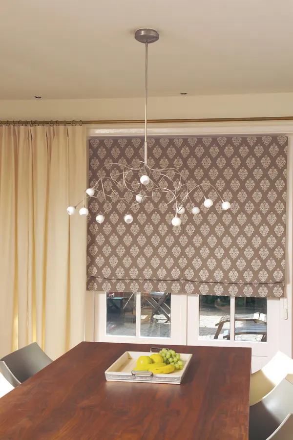 Gemustertes Faltrollo in braun-beige passend zur beigen Gardine am Esszimmerfenster