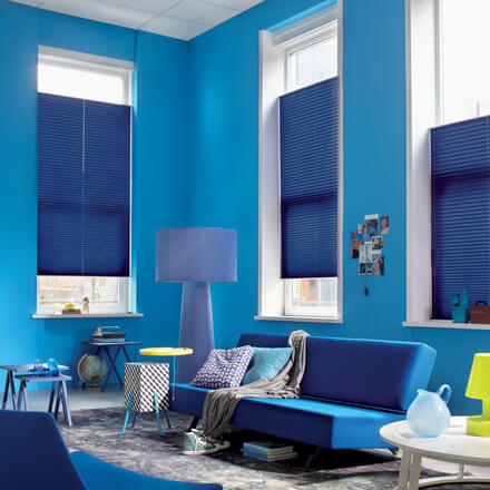 Blaue Plissees mit Bedienung per Doppelschnur im Wohnzimmer
