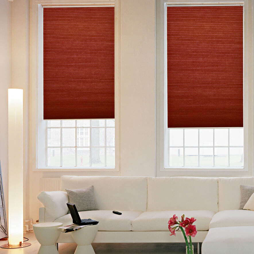 Rote Verdunkelungsplissees im Wohnzimmer