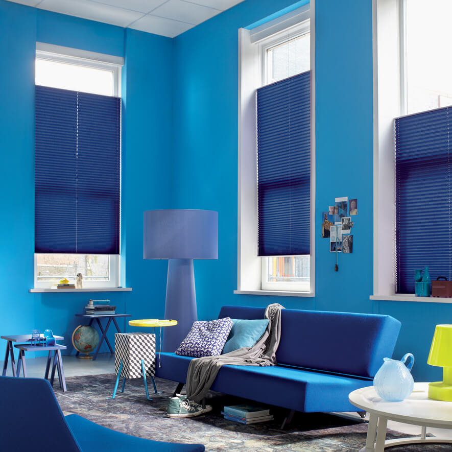 Blaue Plissees mit Bedienung per Doppelschnur im Wohnzimmer